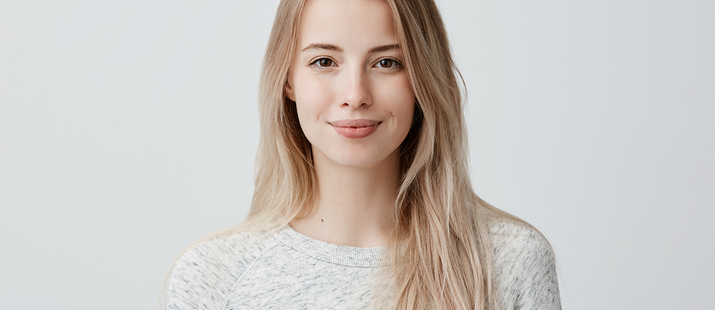Pretty smiling joyfully female with fair hair, dressed casually, looking with satisfaction at camera, being happy.