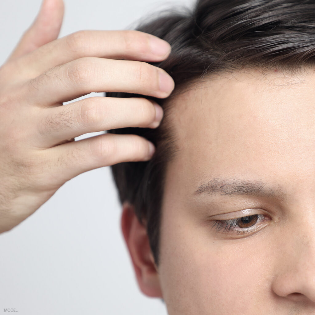 Photo of a man running his fingers through his hair