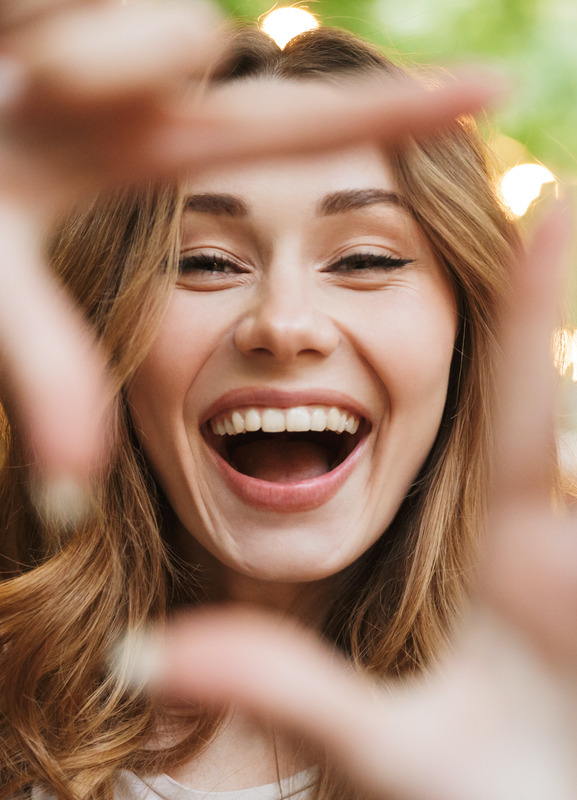 Smiling woman framing her face with her hands